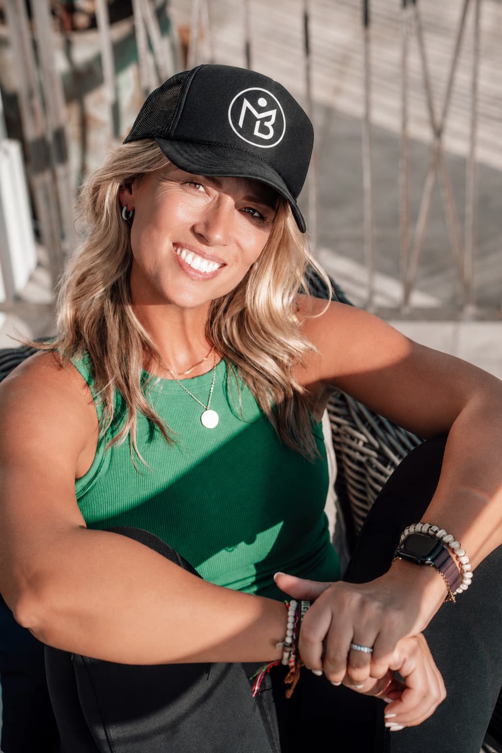 Allie Chapman, founder of Mind Body Athletes, wearing an MBA hat outdoors