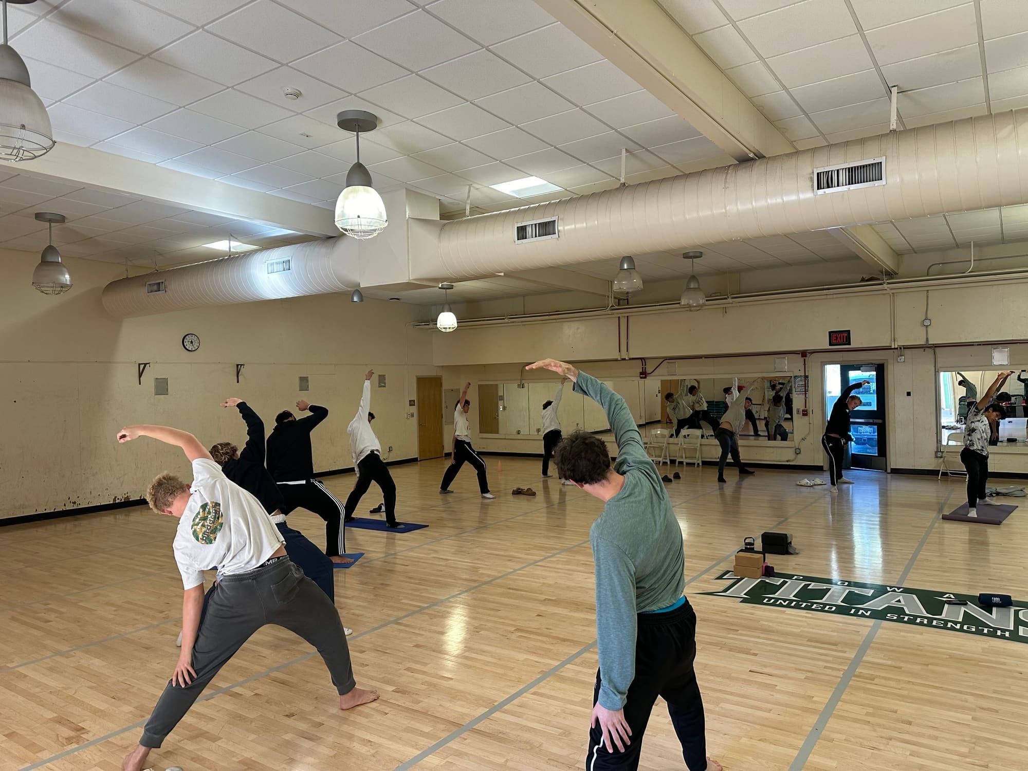 Athletes stretching together during a coach-supported training session