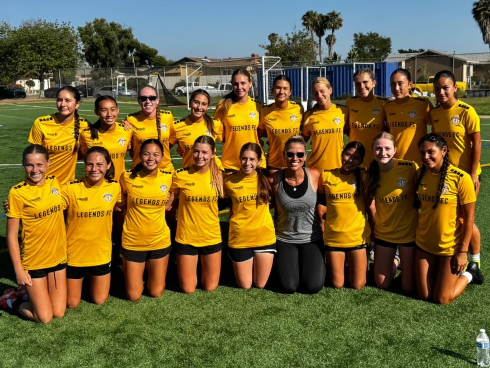 A girls soccer team in yellow with Allie Chapman after a Mind Body Athletes session